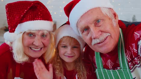 POV-of-senior-grandparents-with-grandchild-girl-taking-selfie-on-mobile-phone-on-Christmas-kitchen