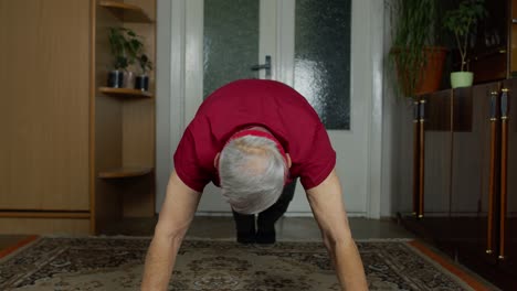 Anciano-Caucásico-Con-Ropa-Deportiva-En-La-Sala-De-Estar,-Haciendo-Ejercicio-Matutino-En-Casa