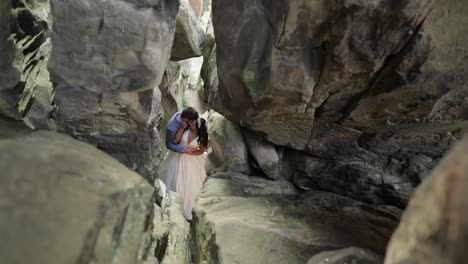 Groom-with-bride-standing-in-cave-of-mountain-hills.-Wedding-couple-in-love