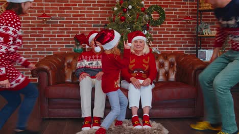 Multigenerational-family-taking-selfie-photo-on-timer-mobile-phone-at-decorated-Christmas-home