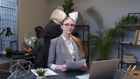 Female-business-company-manager-sitting-at-office-desk-reading-resume,-successful-job-interview