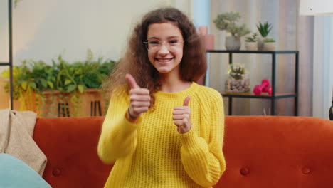 Happy-child-kid-girl-looking-approvingly-at-camera-showing-thumbs-up,-like-positive-sign,-good-news