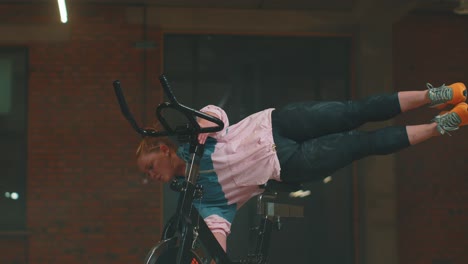 Mujer-Atlética-Hace-Rutina-De-Entrenamiento-Con-Hilo-En-Bicicleta-Estática-Giratoria-En-El-Gimnasio,-Ejercicios-De-Estiramiento