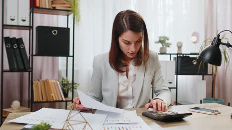 Depressed-desperate-businesswoman-feeling-worried-about-financial-problem-doing-paperwork-at-office