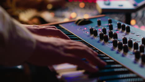 Young-singer-playing-piano-electronic-keyboard-in-control-room