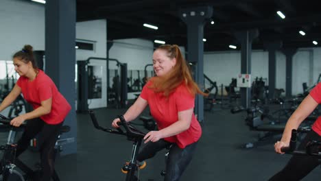 Grupo-De-Chicas-Atléticas-Realizando-Ejercicios-De-Entrenamiento-Aeróbico-En-Bicicleta-Estática-En-El-Gimnasio