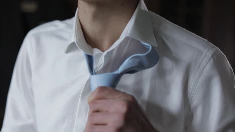 Handsome-groom-fixes-his-blue-bow-tie.-Wedding-morning.-Businessman