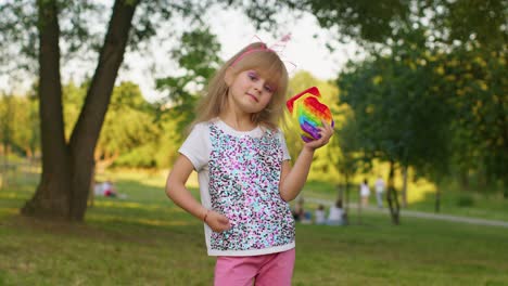 Niña-Sosteniendo-Muchas-Burbujas-De-Silicona-Blandas-Y-Coloridas-Pop-It-Juguetes-Sensoriales-Populares,-Pulgar-Hacia-Arriba