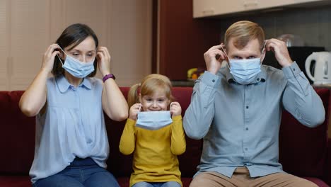 Bloqueo-De-Cuarentena-De-Coronavirus.-Madre,-Padre-E-Hija-Se-Ponen-Máscaras-Médicas-En-La-Cara-En-Casa