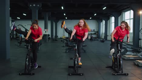 Grupo-De-Amigas-Sonrientes-Clase-De-Mujeres-Haciendo-Ejercicio,-Entrenando,-Girando-En-Bicicleta-Estática-En-El-Gimnasio-Moderno