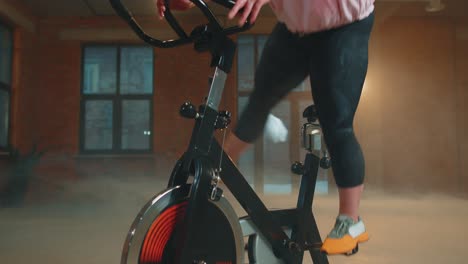 Woman-performs-aerobic-endurance-training-workout-cardio-routine-on-the-simulators,-cycle-training