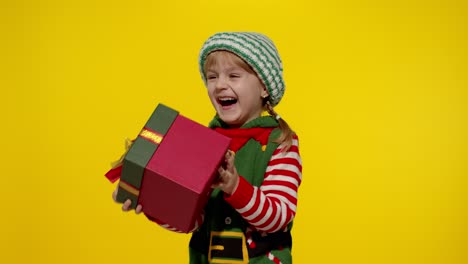 Kid-girl-in-Christmas-elf-Santa-helper-costume-getting,-receiving-present-gift-box.-New-Year-holiday