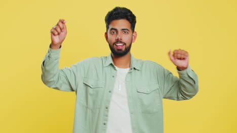 Happy-young-Indian-man-listening-music-dancing-disco-having-fun-relaxing-on-party-making-funny-moves