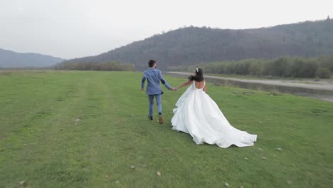 Hochzeitspaar-Läuft-In-Der-Nähe-Des-Gebirgsflusses.-Bräutigam-Und-Braut-In-Der-Liebe