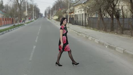 Una-Joven-Atractiva-Con-Un-Vestido-Con-Flores-Caminando-Por-La-Carretera.