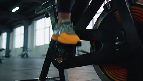 Nahaufnahme-Einer-Sportlichen-Frau,-Die-Beim-Bein-Spinning-Training-Auf-Einem-Stationären-Fahrrad-Im-Innenbereich-Trainiert