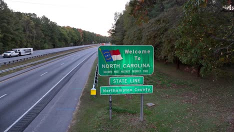 Welcome-to-North-Carolina-state-sign-along-interstate-highway-during-sunset