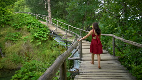 Woman-traveler-enjoys-waterfall-in-Plitvice-Lakes