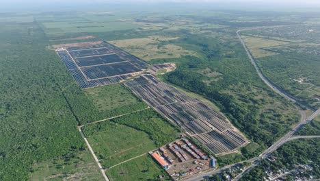 Vista-Aérea-De-Paneles-Solares-Rodeados-De-Campos-De-Vegetación-Verde-Durante-El-Día-Soleado-En-La-Romana.