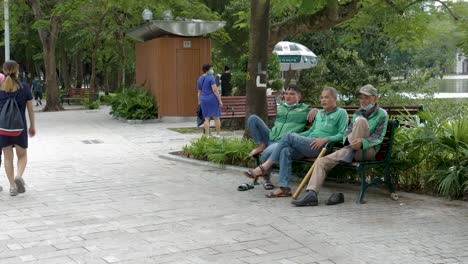 Tome-A-Los-Conductores-De-Servicio-De-Hanoi-Sentados-Para-Charlar-Durante-El-Descanso-En-El-Parque-Local.