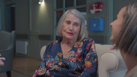 Slow-motion-shot-of-a-elderly-woman-speaking-with-her-daughter-in-a-care-home