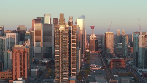 De-Izquierda-A-Derecha,-La-Ciudad-De-Calgary,-Alberta,-Se-Ve-Desde-El-Punto-De-Vista-De-Un-Dron-Aéreo-Durante-La-Hora-Dorada,-Reflejando-El-Cálido-Resplandor-Amarillo-Del-Sol.