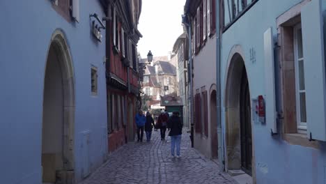 Turistas-Caminando-Por-Pequeñas-Calles-Con-Caminos-De-Piedra-Caliza-En-Colmar,-Francia