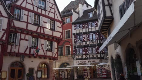 Malerische-Aussicht-Auf-Restaurants-Und-Geschäfte-In-Den-Mittelalterlichen-Fachwerkgebäuden,-Touristisches-Französisches-Dorf,-Colmar