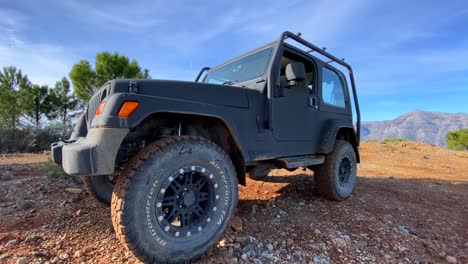 Jeep-Negro-4x4-En-Un-Día-Soleado-En-La-Cima-De-La-Montaña-Sierra-Bermeja-Con-árboles-Verdes,-Divertidas-Aventuras-En-Vehículos-Todo-Terreno-En-Marbella-Málaga-España,-Toma-De-4k