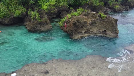 Magpupungko-Gezeitenfelsenbecken-Mit-Menschen,-Die-Im-Klaren-Blauen-Wasser-Springen-Und-Schwimmen