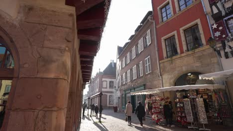 Schöne-Morgensonne-Scheint-Durch-Die-Straßen-Der-Mittelalterlichen-Stadt-In-Frankreich.-Menschen-Laufen-Durch-Das-Geschäftsviertel