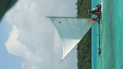 Tourists-sailing-on-traditional-outrigger-canoe,-or-pirogue-on-Upi-Bay