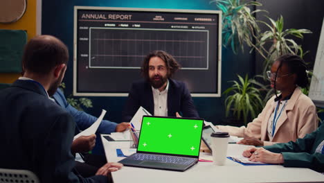 Business-partners-attending-meeting-next-to-greenscreen-laptop