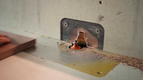 Machinist-at-work-performing-tasks-on-wood-shaper,-close-up