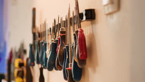 Close-up-of-various-woodworking-tools-on-rack,-panning-shot