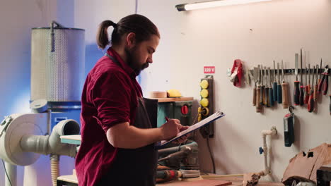 Carpenter-drawing-blueprints-on-notepad-in-studio