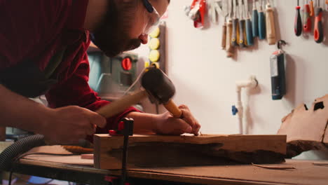 Artist-uses-vice-tool-to-clamp-piece-of-wood,-shaping-log