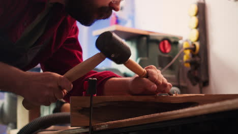 Artist-uses-vice-tool-to-clamp-piece-of-wood,-shaping-log