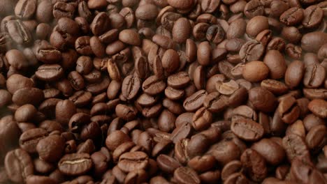 Close-up-of-seeds-of-coffee.-Fragrant-coffee-beans-are-roasted-smoke-comes-from-coffee-beans.