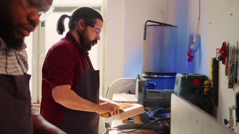 Coworking-artisans-in-studio-using-sandpaper-and-wood-shaper