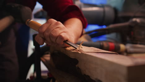 Manufacturer-in-studio-shaping-wooden-pieces-with-tools,-close-up