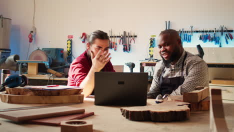 Cabinetmakers-doing-brainstorming-while-using-laptop