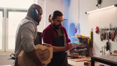 Carpenter-and-colleague-looking-over-technical-schematics,-brainstorming-ideas