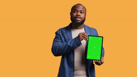 Portrait-of-man-doing-influencer-marketing-using-green-screen-tablet