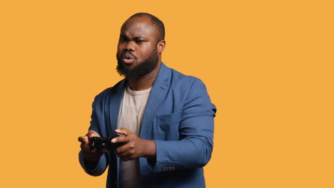 Portrait-of-cheerful-man-playing-videogames-with-controller,-studio-background