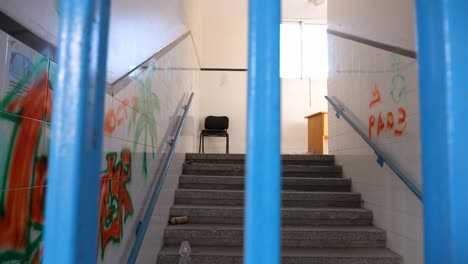 Abandoned-house-interior-in-Gaza,-chair-on-top-of-the-stairs