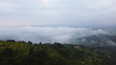 Aerial-flyover-tropical-hills-with-houses-in-suburb-area-of-Pokhara-in-Nepal---Flying-clouds-in-the-sky