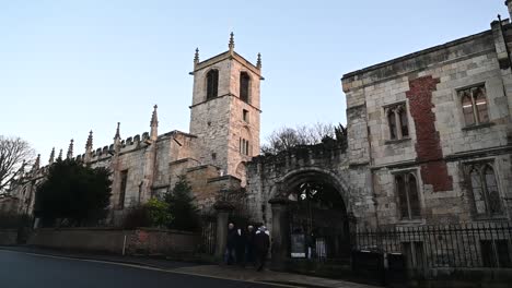 Walking-past-St-Olave's-Church-York,-Yorkshire,-United-Kingdom