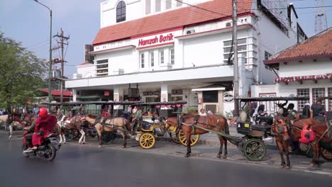 Filas-De-Carruajes-Tirados-Por-Caballos-Estacionados-Al-Lado-De-La-Carretera-Malioboro