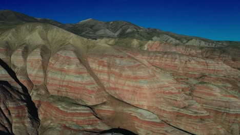 Vista-Aérea-Petra,-Jordania,-Cámara-De-Drones-De-Oriente-Medio-Avanzando-Donde-Dos-Están-Parados-En-Una-Montaña-Tomando-Fotos